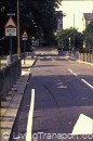 11. Bethnal Green (London) Not a 20 mph zone as such but an example of speed humps UK (London) style which are generally effective in limiting speeds at the humps to about 30 kmph or 20 miles per hour. However, the character of the street is unchanged. The use of signs, road markings pedestrian guard rails etc still conveys the impression of a traffic priority street. Drivers therefore tend to resent humps as obstructions. No advice is given on the appropriate speed. The legal limit remains at 30 mph even though it is no longer possible to negotiate the street at this speed. In this example, humps are located away from the zebra crossing (to comply with Department of Transport regulations) so speeds are highest where pedestrians cross! Guard rails compel pedestrians to cross at the zebra.