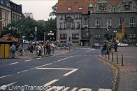 37. Bergisch Gladbach (near Cologne, Germany) Through road narrowed where pedestrian area crosses at light-controlled crossing. General traffic queues in centre lane (foreground) while buses gain priority through the signal at green.