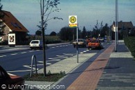 39. Albachten (near Munster, Germany) Village through road with 50 kmph speed limit. Footway built out to edge of main carriageway at bus stop. When bus is stopped, other traffic must wait behind. Note also defined parking bays either side and cycle lane in red brick. This and the photo of Dulmen Buldern show examples of a series of treatments on the national (Federal) road No 51 between Munster and Bochum.