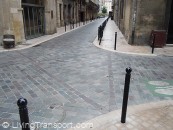 Bollards Bordelais 6 - Simple round-top design protects pedestrian space, and is varied with closed modules at intervals. Corners are vulnerable, but see bendy bollard pic. Note the careful stonework within the manhole cover.          