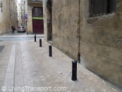 Bollards Bordelais 8 - Cannon-style bollards, but set much lower than usual. The flush surface and drainage channel in similar stone is done with care.